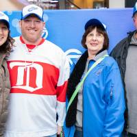 Four alumni stand together for a photo at the Detroit Red Wings GVSU Night